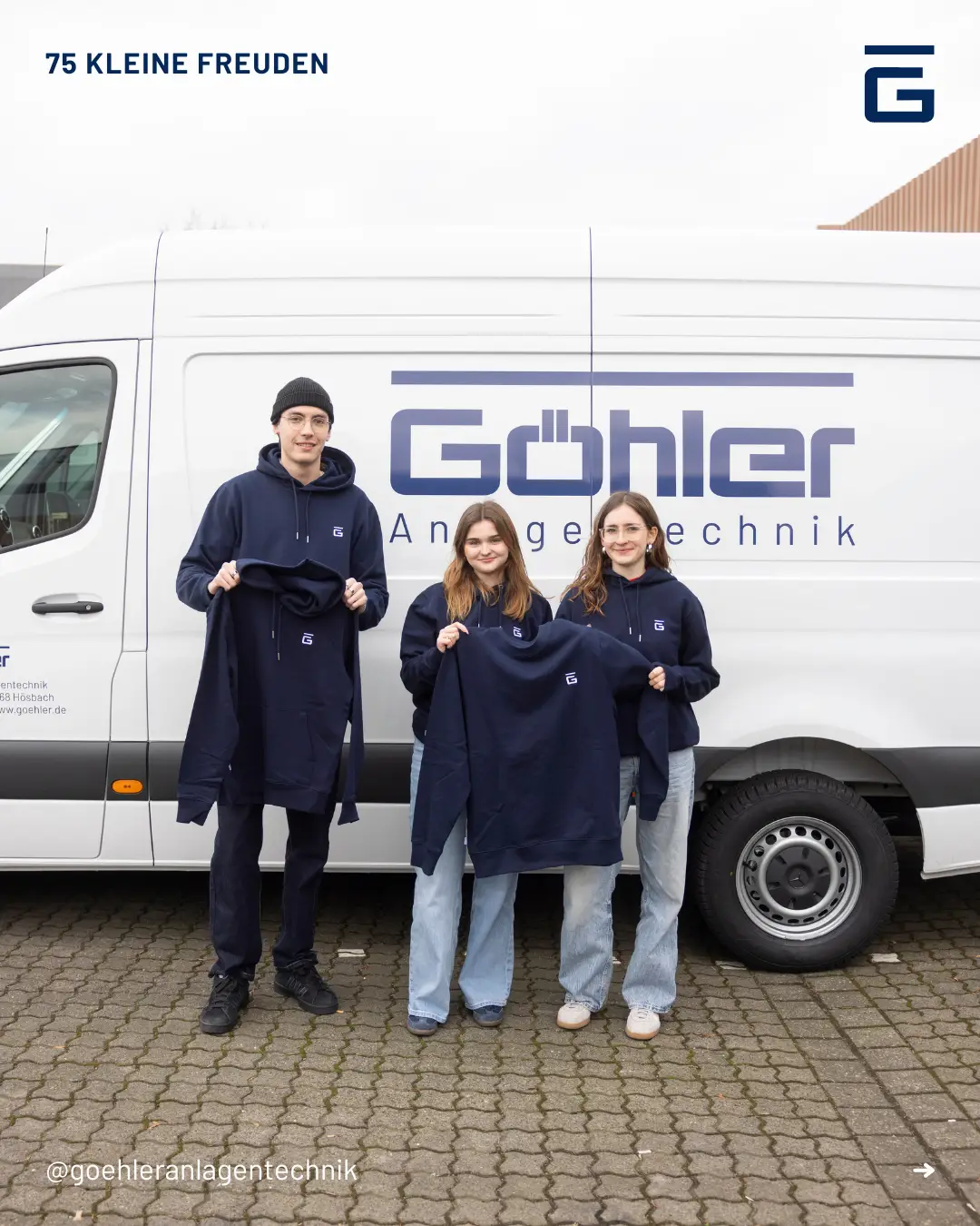 3 Mitarbeiter die Göhler pullovers in der Hand halten